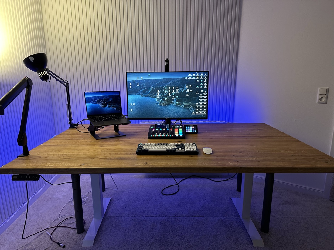 Aufgeräumter Schreibtisch mit Laptop, Monitor und Tastatur ohne Ablenkungen